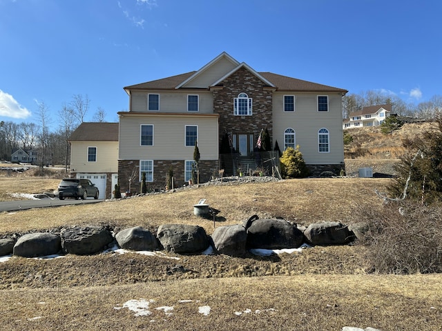 view of front facade featuring stone siding and an attached garage