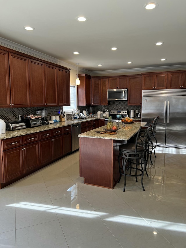 kitchen featuring appliances with stainless steel finishes, decorative backsplash, a kitchen bar, and light tile patterned floors