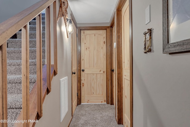 corridor featuring stairs and carpet