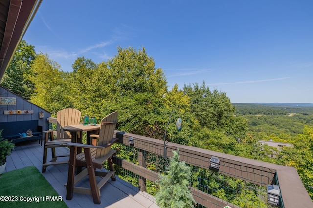 wooden terrace featuring a wooded view