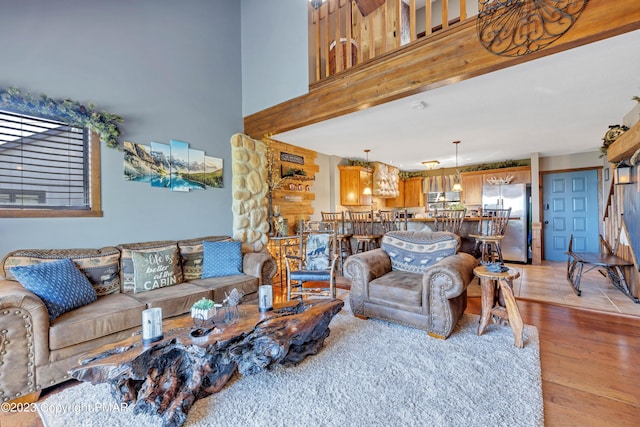 living area with light wood finished floors and a high ceiling