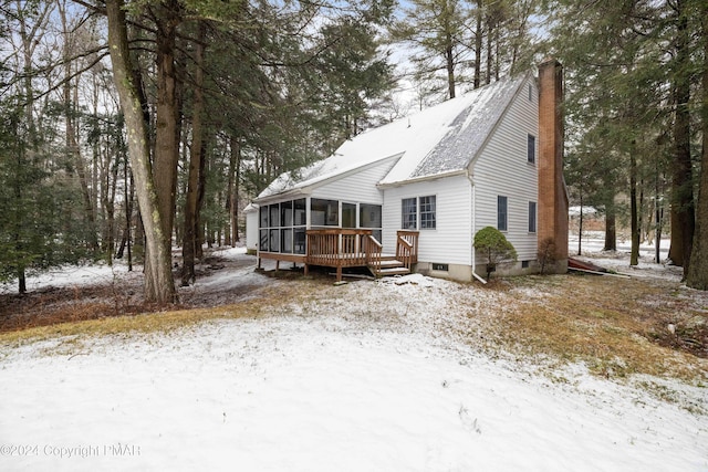 view of front of home featuring a chimney and a sunroom