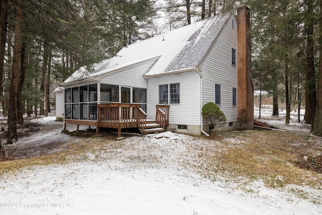 view of front facade with a sunroom and a chimney