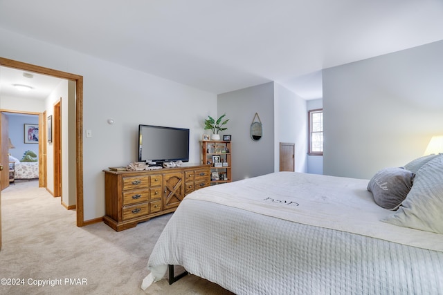 bedroom with light carpet and baseboards