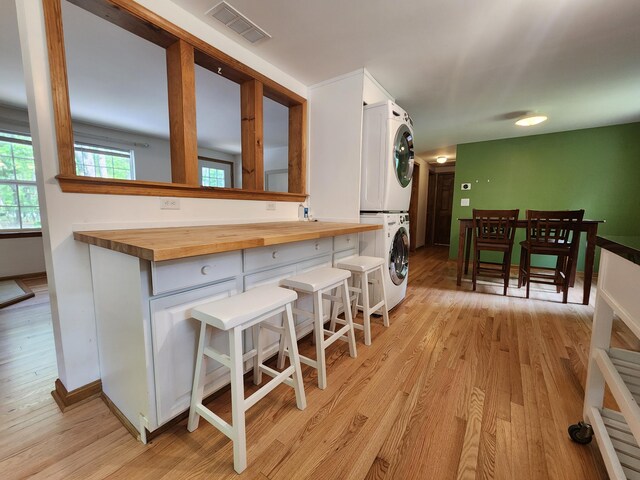 9 Theocritus Cir, Albrightsville, PA 18210 - kitchen with stacked washer and clothes dryer, butcher block counters, white cabinets, and light wood finished floors