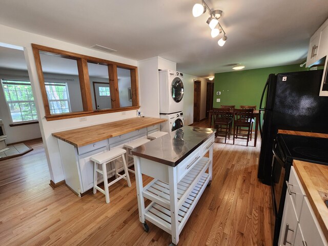 9 Theocritus Cir, Albrightsville, PA 18210 - kitchen featuring wood counters, stacked washer / dryer, black range with electric stovetop, and light wood-type flooring