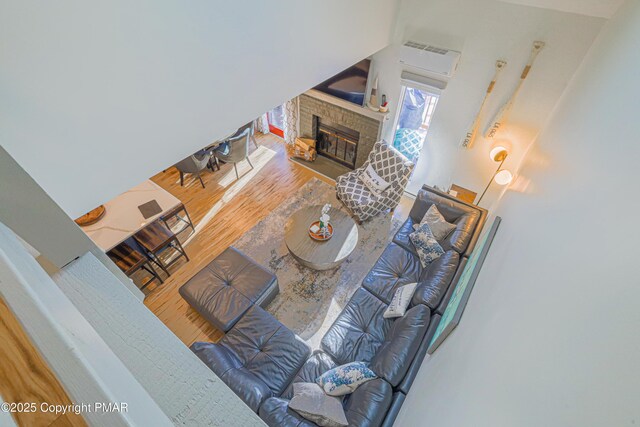 living room featuring hardwood / wood-style flooring and a brick fireplace