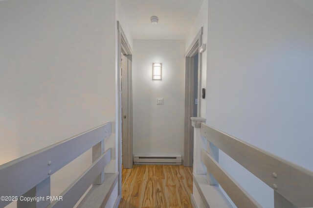 corridor with a baseboard radiator and light hardwood / wood-style floors