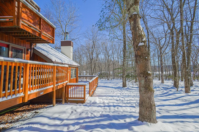 yard layered in snow featuring a wooden deck