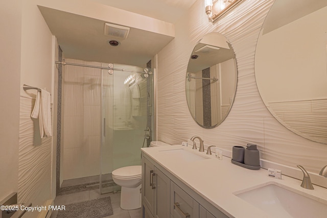 bathroom with toilet, vanity, tile patterned floors, and walk in shower