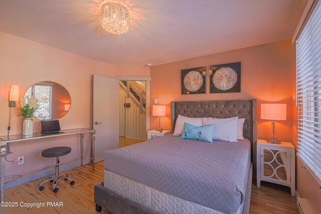 bedroom featuring hardwood / wood-style floors and an inviting chandelier