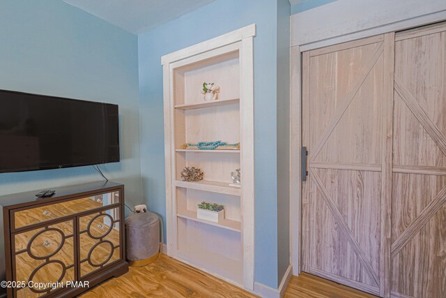 interior space featuring hardwood / wood-style floors and built in shelves