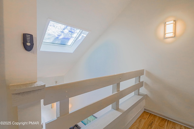 stairs featuring wood-type flooring and a skylight