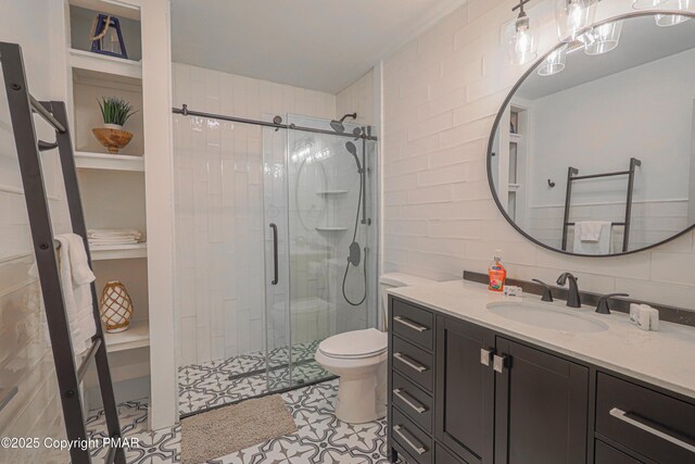 bathroom with tile walls, backsplash, vanity, walk in shower, and toilet