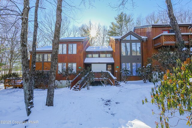 snow covered house with a deck