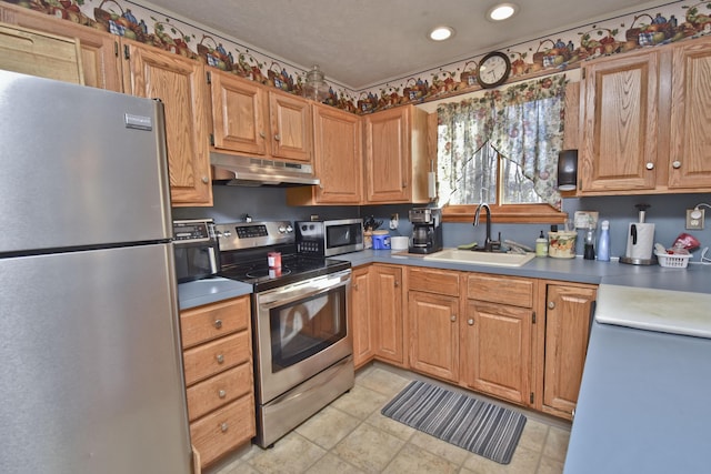 kitchen with under cabinet range hood, appliances with stainless steel finishes, recessed lighting, and a sink