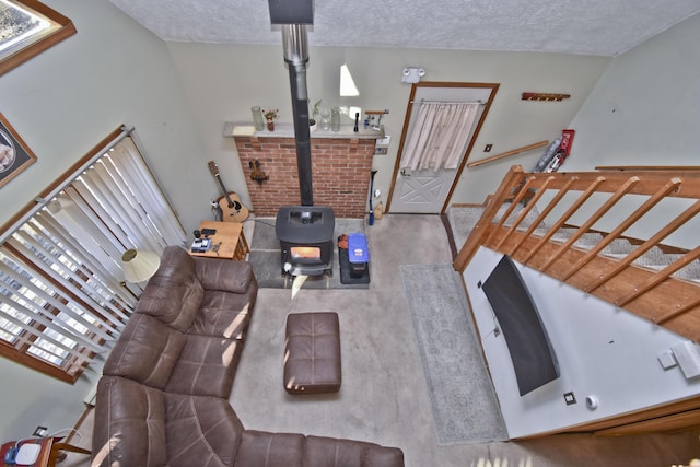 living area with a wood stove and a textured ceiling