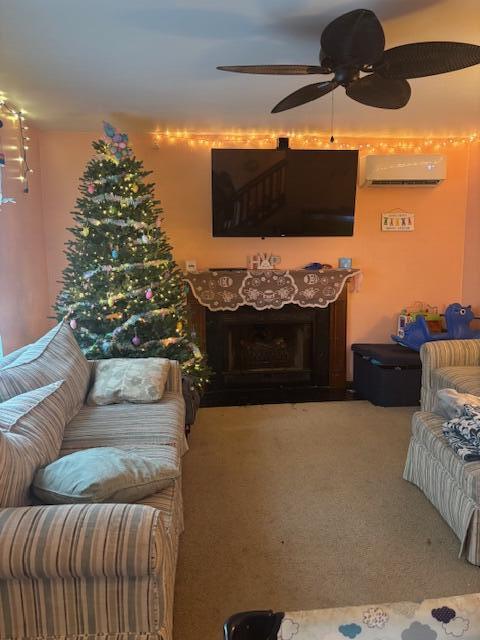 living room with a premium fireplace, carpet, ceiling fan, and a wall mounted air conditioner
