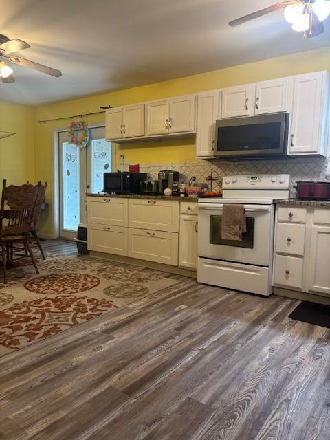 kitchen featuring a ceiling fan, tasteful backsplash, dark wood-type flooring, stainless steel microwave, and white electric stove