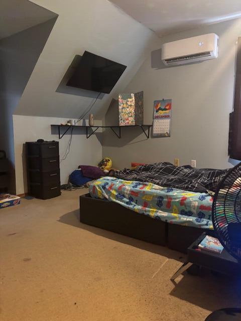 bedroom with vaulted ceiling, a wall mounted AC, and carpet floors