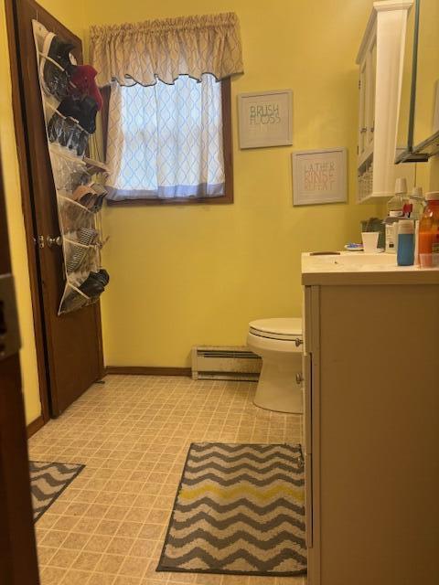 bathroom featuring baseboards, vanity, a baseboard radiator, and toilet