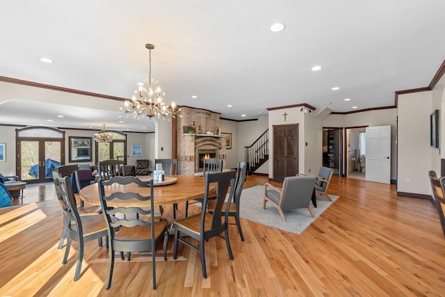 dining room featuring french doors, recessed lighting, light wood-style floors, a brick fireplace, and baseboards