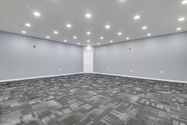 carpeted spare room featuring baseboards and recessed lighting