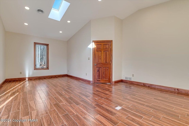 empty room featuring a skylight, visible vents, and light wood-style floors