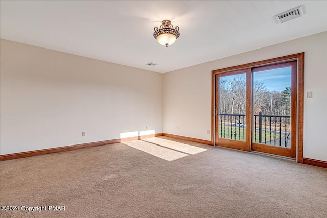 carpeted empty room featuring visible vents and baseboards