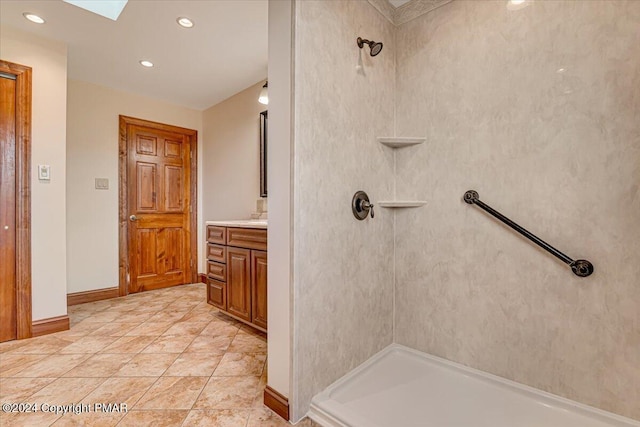 full bathroom with baseboards, tile patterned floors, a tile shower, vanity, and recessed lighting