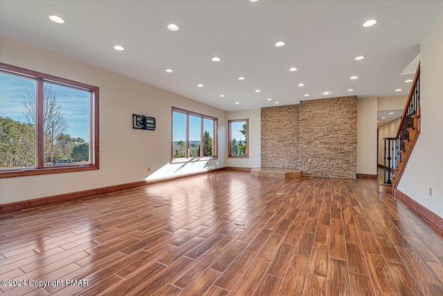 unfurnished living room with baseboards, wood finished floors, and recessed lighting