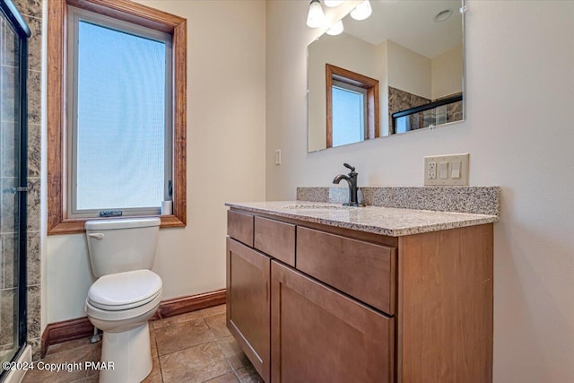 full bathroom with toilet, baseboards, a tile shower, and a wealth of natural light