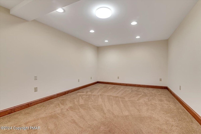 empty room featuring recessed lighting, light carpet, and baseboards