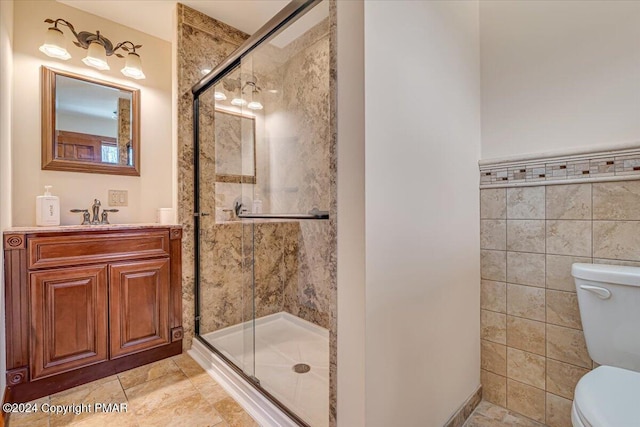 bathroom featuring a stall shower, toilet, and tile walls