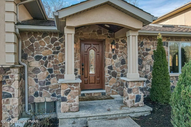 property entrance featuring stone siding and stucco siding