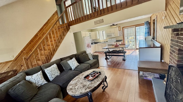 living room with a high ceiling, hardwood / wood-style flooring, and stairs