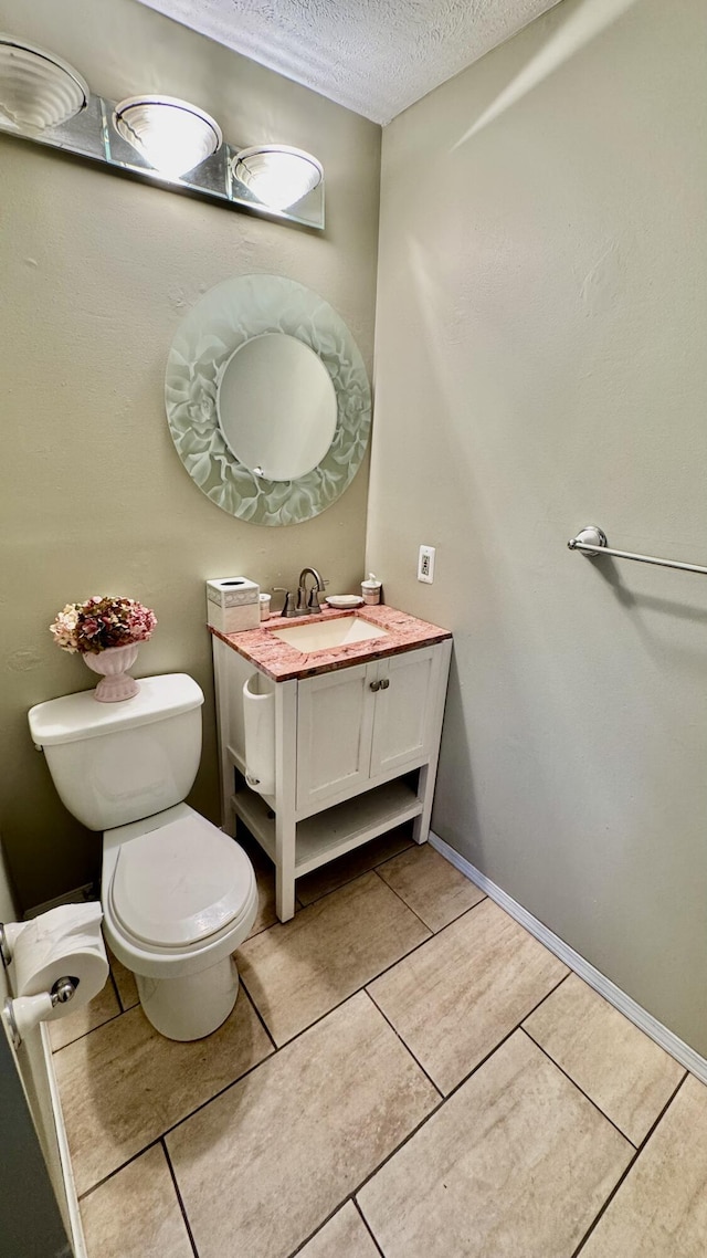 bathroom featuring vanity, tile patterned floors, toilet, and a textured ceiling