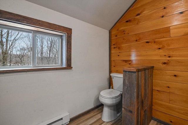 bathroom with toilet, wood finished floors, vaulted ceiling, and baseboard heating