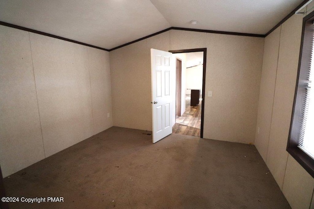 empty room with vaulted ceiling and crown molding