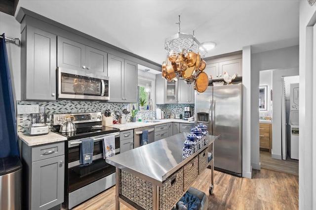 1237 Brentwood Dr, East Stroudsburg, PA 18301 - kitchen featuring appliances with stainless steel finishes, gray cabinets, decorative backsplash, and light wood-type flooring