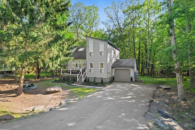 1237 Brentwood Dr, East Stroudsburg, PA 18301 - view of front facade with asphalt driveway, a garage, a deck, and view of scattered trees