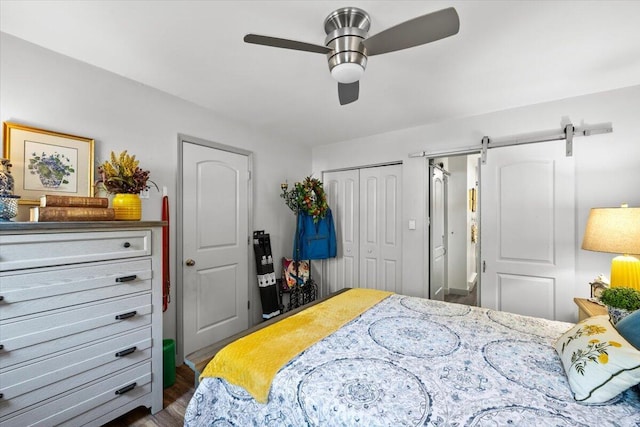 1237 Brentwood Dr, East Stroudsburg, PA 18301 - bedroom with dark wood-style flooring, a ceiling fan, and a barn door