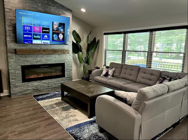 living room featuring recessed lighting, lofted ceiling, wood finished floors, and a fireplace