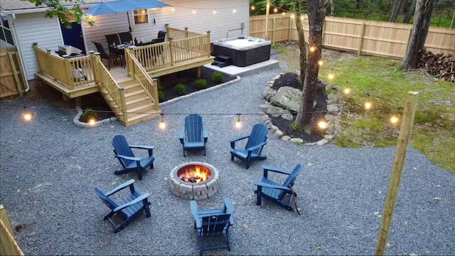 exterior space with a patio area, a fire pit, a fenced backyard, a hot tub, and a wooden deck