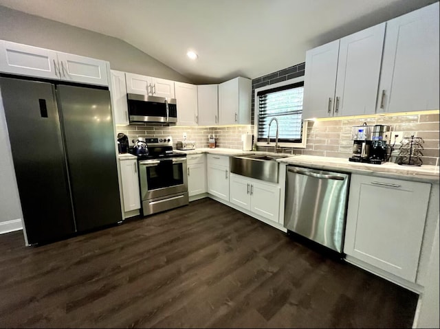 kitchen with lofted ceiling, light countertops, a sink, and appliances with stainless steel finishes
