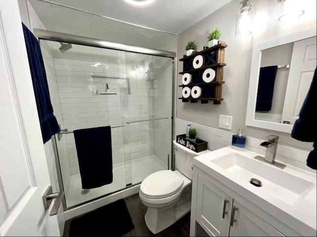 bathroom featuring a shower stall, toilet, and vanity