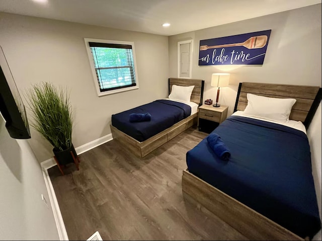 bedroom with baseboards, wood finished floors, and recessed lighting