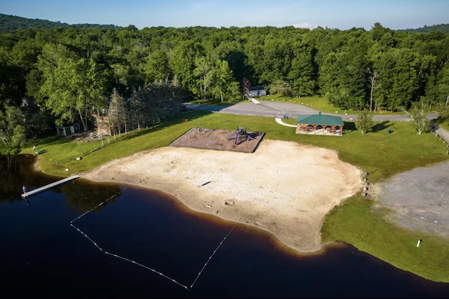 birds eye view of property featuring a water view and a wooded view