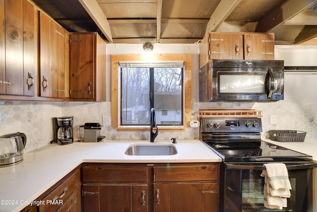 kitchen with black appliances, a sink, light countertops, and decorative backsplash