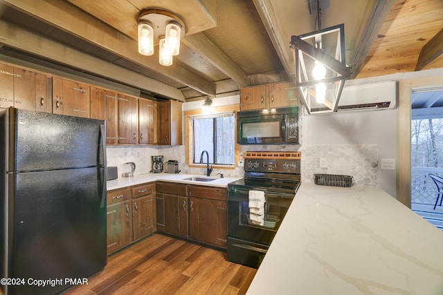 kitchen featuring beam ceiling, decorative backsplash, a sink, plenty of natural light, and black appliances